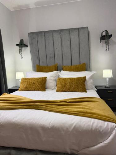una camera da letto con un letto grande con cuscini gialli di Elevare suites a Nelspruit