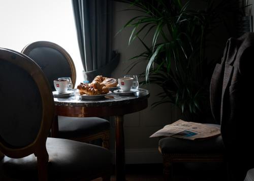 ein Tisch mit einem Teller mit Essen und Tassen darauf in der Unterkunft Locanda Sibilla Luxury Suites in Tivoli