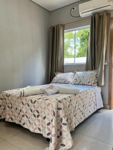 a bedroom with a bed and a window at Fica Aki - Hospedagem Alta Floresta in Alta Floresta