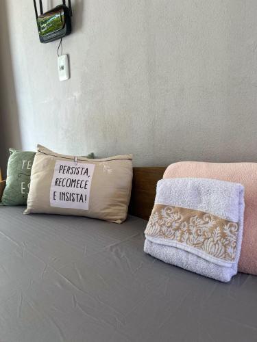 a bed with a pillow with a sign on it at Fica Aki - Hospedagem Alta Floresta in Alta Floresta