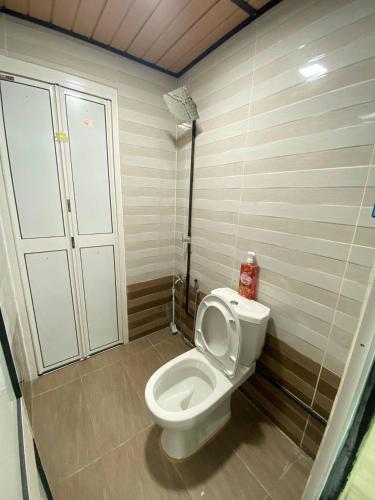 a bathroom with a white toilet in a room at Umishah Cabin Jitra in Jitra