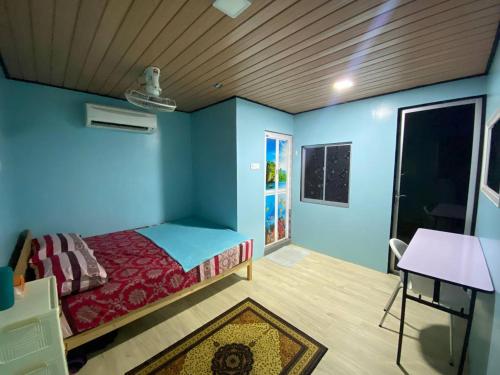 a bedroom with a bed in a room with blue walls at Umishah Cabin Jitra in Jitra
