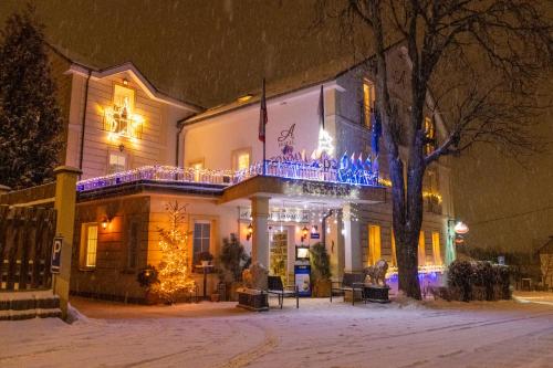 a building with christmas lights on it in the snow at Hotel Tommy Wellness & Spa in Náchod