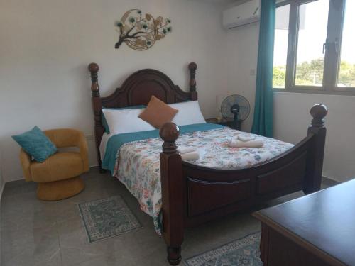 a bedroom with a large bed and a chair at 4K-Suite in Kingston