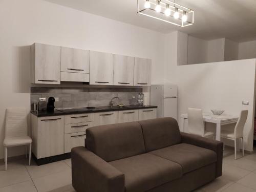 ein Wohnzimmer mit Sofa und eine Küche in der Unterkunft Appartamento Suite Antiche Terme - Zero Barriere in Acqui Terme