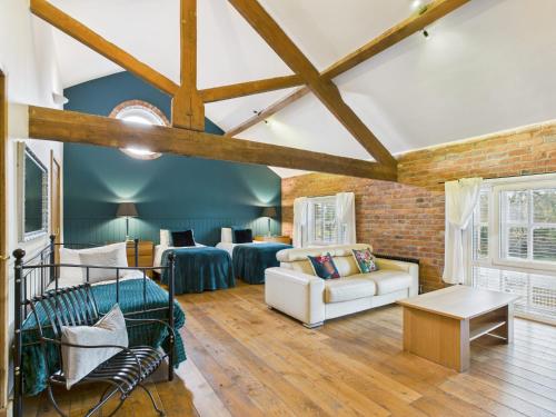 un soggiorno con due letti e un divano di The Old Granary Country-retreat a Burton Agnes