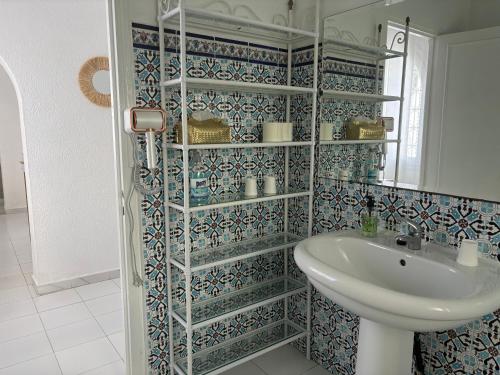 a bathroom with a sink and a shower with blue tiles at Casa Madame Aïcha in Sousse
