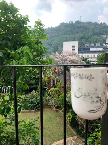een witte kom die op een balkonreling staat bij Teirack Rosis Wish in Kandy