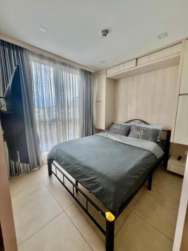 a bedroom with a bed and a large window at City Garden Olympus condo balcony in Pattaya South
