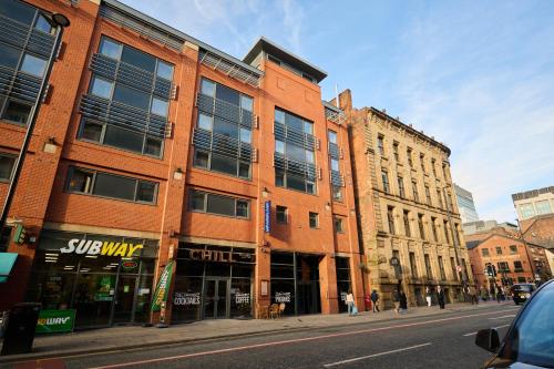 a red brick building on a city street at a&o Manchester City Centre in Manchester