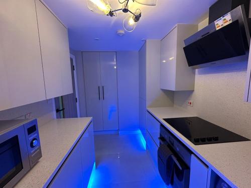 a kitchen with blue lights on the counters at Modern, comfortable flat close to transport hubs in Stockport
