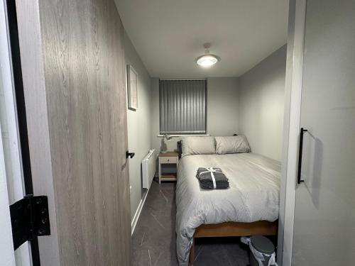 a small bedroom with a bed and a small hallway at Modern, comfortable flat close to transport hubs in Stockport