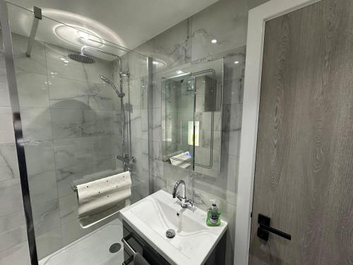 a bathroom with a sink and a shower at Modern, comfortable flat close to transport hubs in Stockport