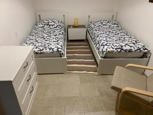 twee bedden in een kleine kamer met een keuken bij Villa Santa Lucia in Noto