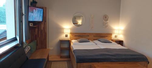 a small bedroom with a bed and a television at Apartment Nähe Wolfgangsee Salzkammergut in Strobl