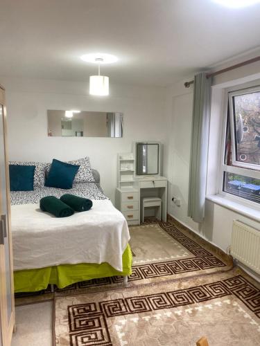 a bedroom with a bed with blue pillows and a television at Great apartment, Great location for 6 guests in London
