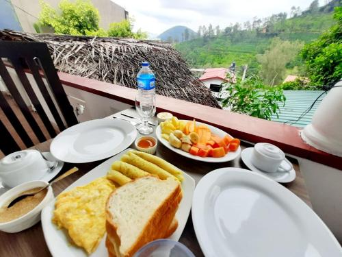 een tafel met borden met ontbijtvoedsel op een balkon bij Green Villa Ella in Ella