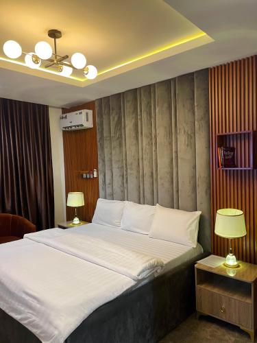 a bedroom with a large bed and two lamps at Exotic Two bedroom apartment in Abuja