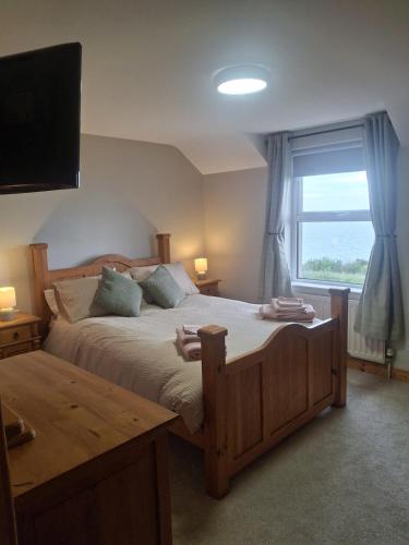 a bedroom with a large bed and a window at Redbrae cottage in Carnlough