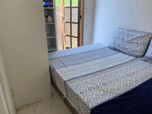 a bed in a room next to a door at Antonia Hospedaria 1 in Búzios