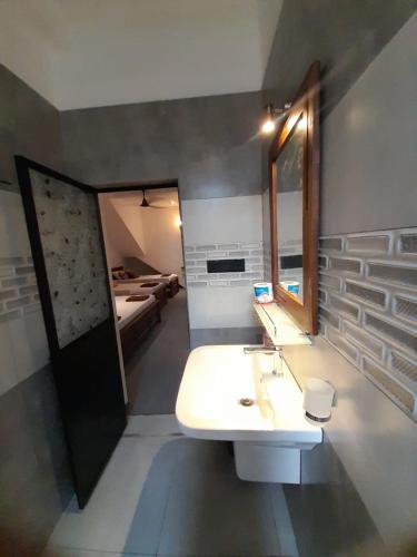 a bathroom with a sink and a mirror and a bed at Hiri Dudes Villa in Dickwella
