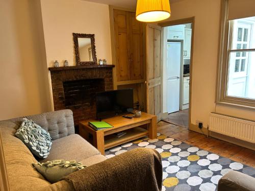 a living room with a couch and a tv at Gorgeous House by City Walls in Canterbury