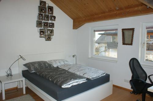 a bedroom with a bed and a desk and a window at Haus & Apartment am Lahnbach in Schwaz