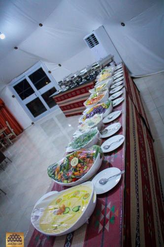 a long line of plates and bowls on a table at Wadi Rum in Al Jafr