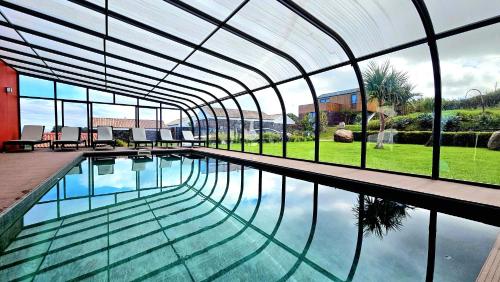a swimming pool in a building with a glass ceiling at Pátio Ecolodge in Cedros