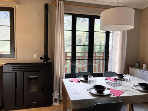 a dining room with a table and a large window at Buenavista Candanchu in Candanchú