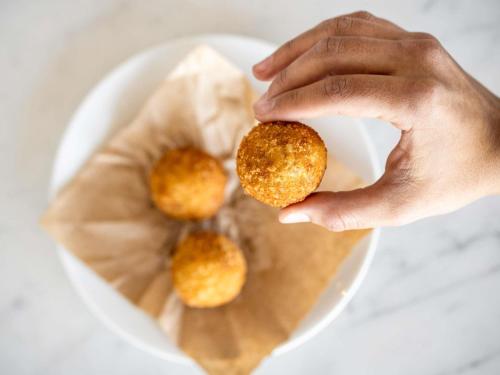 a person holding a piece of food on a plate at Costanero Hotel Montevideo - MGallery Collection in Montevideo