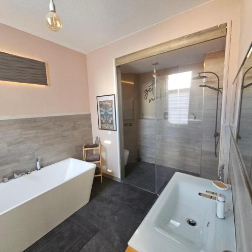 a bathroom with a tub and a sink and a shower at Anno 1889 in Plauen