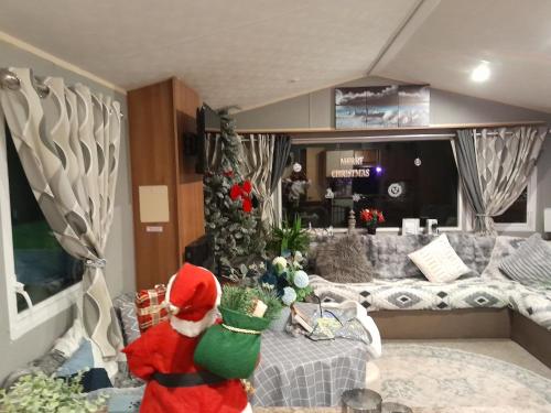 a santa claus is standing in a living room at Static caravan - sleeps 8 in Great Driffield