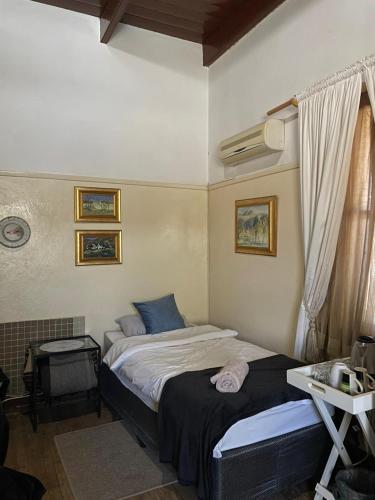 a bedroom with two beds and a desk and a window at Ark Gastehuis and Williston Mall in Williston