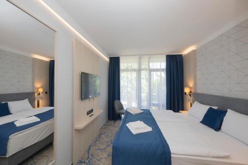 ein Hotelzimmer mit zwei Betten und einem Fenster in der Unterkunft AquaMed Hotel Harkány in Harkány