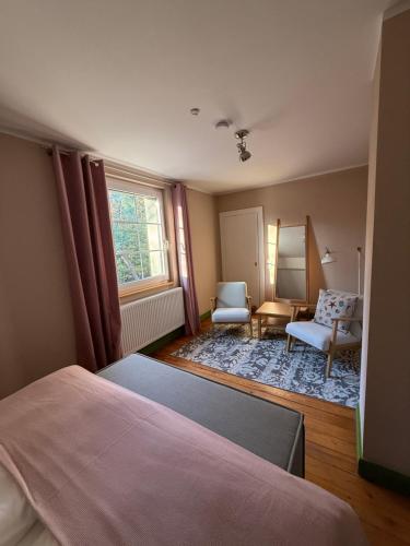 een slaapkamer met een bed, een stoel en een raam bij Strandvilla Waldhaus in Boltenhagen