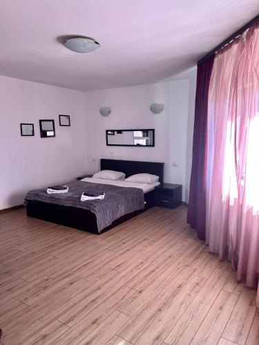 una camera da letto con un letto e un pavimento in legno di Hotel Draculaa Bran a Bran