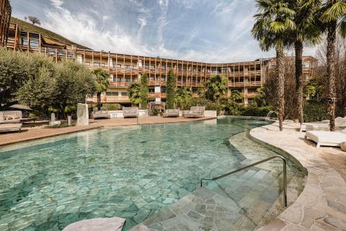 a large swimming pool in front of a building at Lake Spa Hotel SEELEITEN in Caldaro