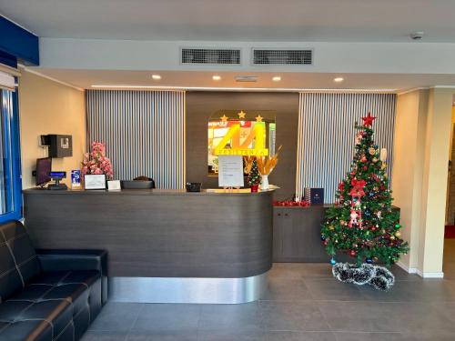 een kerstboom in de lobby van een restaurant bij Blu Hotel in Buccinasco