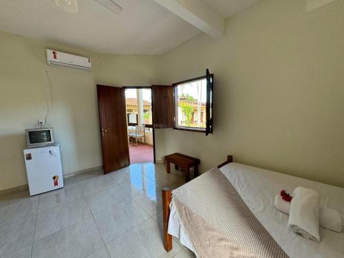 una camera con letto e piccolo frigorifero di Pousada Vila Verde a Olivença