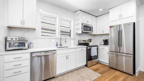 a kitchen with white cabinets and stainless steel appliances at 5BR plus Den - Downtown OC - Sleeps 16 in Ocean City
