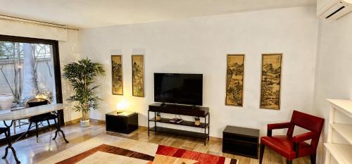 a living room with a flat screen tv on a wall at Beautiful 36m2 studio apartment & 50m2 terrace in Cannes