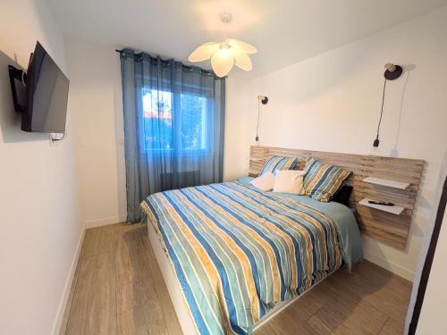 a bedroom with a bed and a flat screen tv at À l'ombre du pin in Entraigues-sur-la-Sorgue