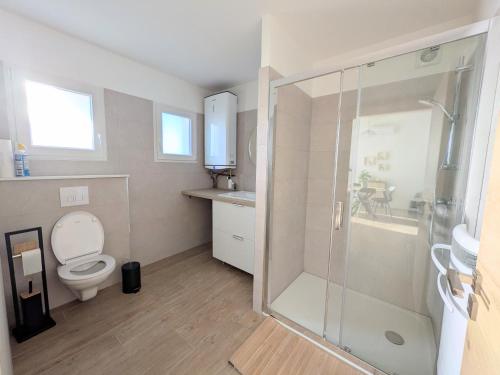 a bathroom with a toilet and a glass shower at À l'ombre du pin in Entraigues-sur-la-Sorgue