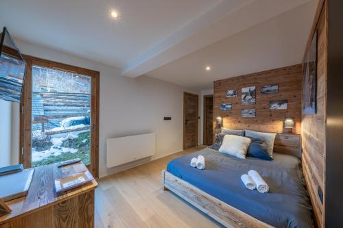 a bedroom with a large bed and a window at Le Chalet 138 Megève séjour pour 8 confort espace charme calme in Demi-Quartier
