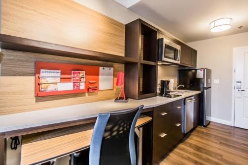 a kitchen with wooden cabinets and a counter top at TownePlace Suites by Marriott Evansville Newburgh in Newburgh