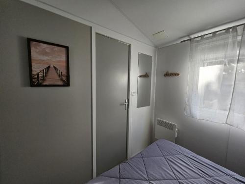 a bedroom with a bed with a picture on the wall at O'ContisParadise 2 in Saint-Julien-en-Born