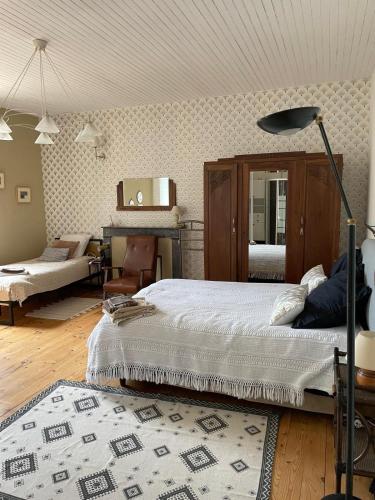 a bedroom with a large bed and a living room at Domaine du plô, Tarn in Trévien