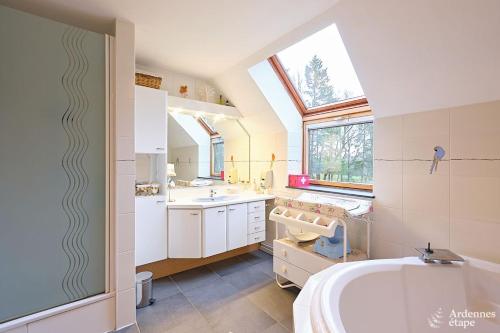 een badkamer met een groot wit bad en een raam bij Gite des étangs de Saint Bale in Vrigne-aux-Bois