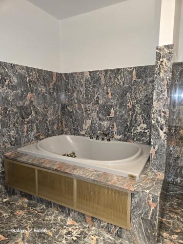 a bath tub in a bathroom with black marble at Villa Trigatti in Galleriano